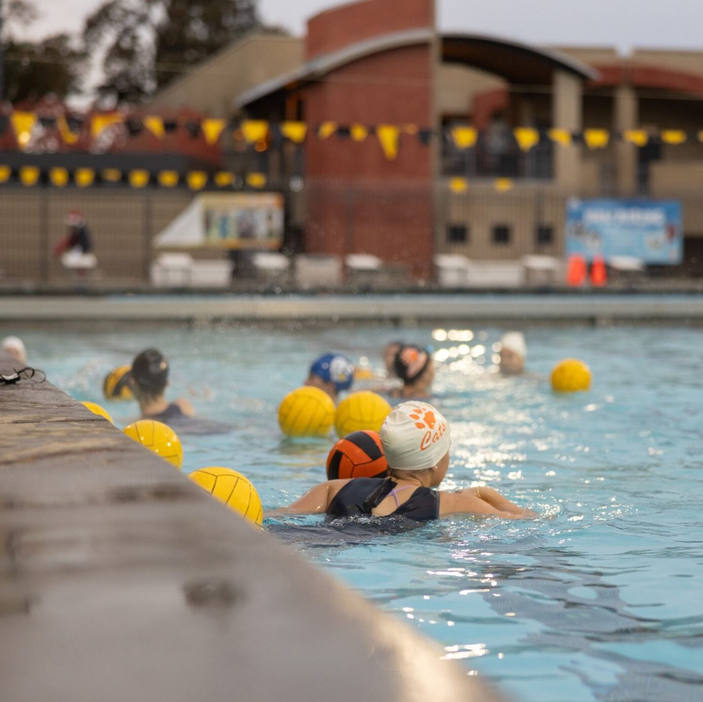 Swimmers in the pool playing water polo