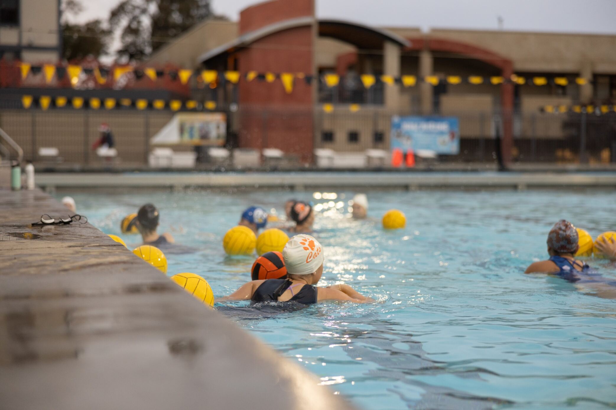 Swimmers in the pool playing water polo