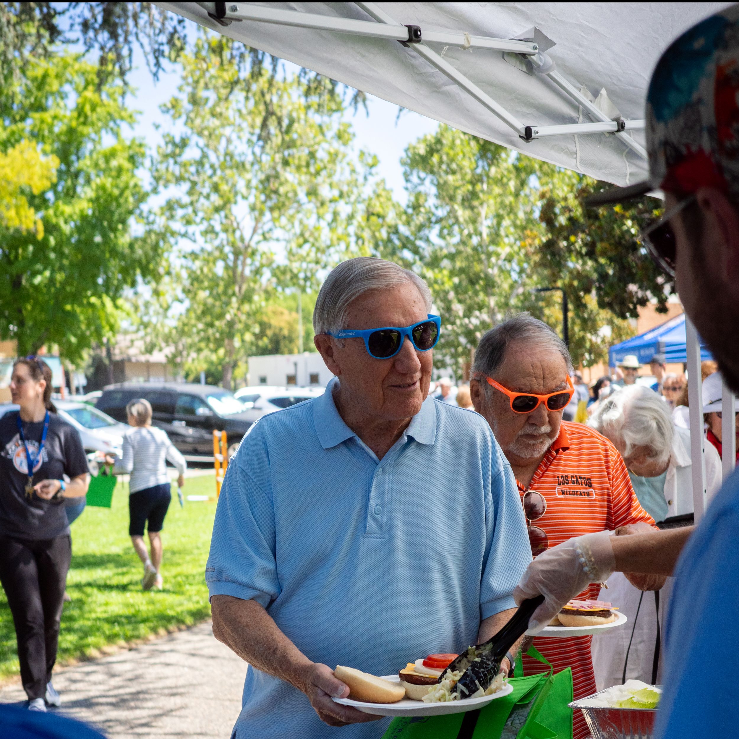 seniors getting served burgers for picnic
